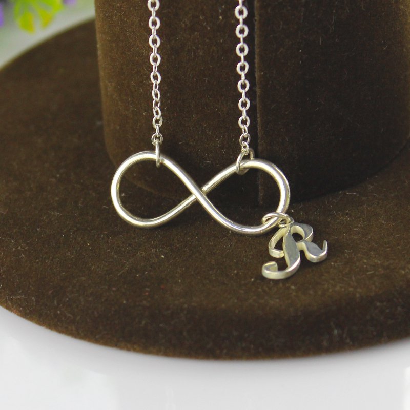Close view of the infinity necklace and initial charm